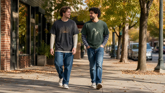 Two friends wearing graphic tees over lightweight long-sleeve shirts on an early-fall city walk