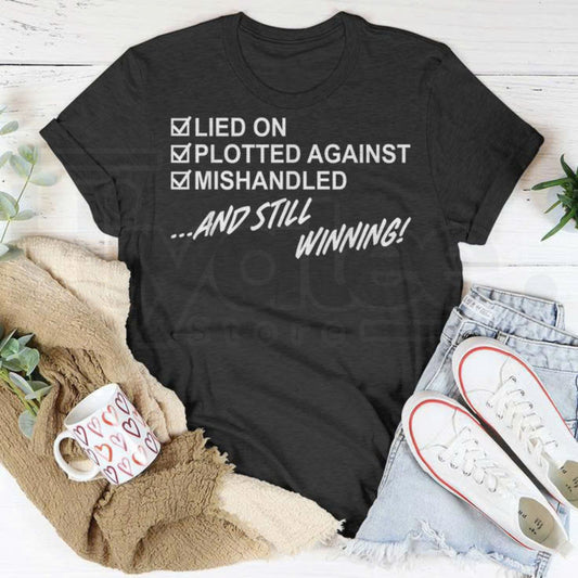 "Lied On, Plotted Against, Still Winning" Unisex T-Shirt – Resilience Graphic Tee - Hiyatee